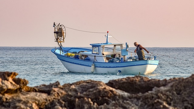 Man stands on side of boat in ocean at Indy Boat, Sport & Travel Show 2024